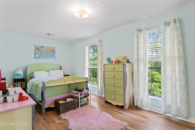 bedroom featuring multiple windows and light wood-type flooring