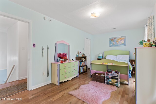 bedroom featuring wood finished floors and baseboards