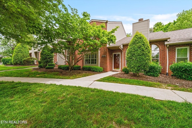 5039 Griffins Gate Ln, Knoxville, TN 37912 - townhome / multi-family property featuring roof with shingles, brick siding, a front lawn, and a chimney
