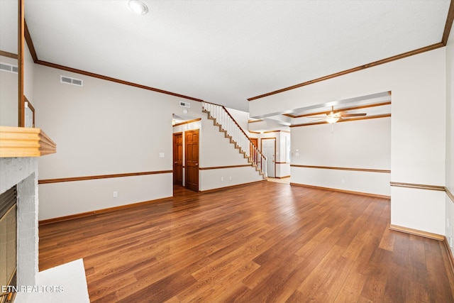 5039 Griffins Gate Ln, Knoxville, TN 37912 - unfurnished living room featuring a ceiling fan, stairs, crown molding, wood finished floors, and a fireplace