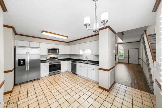 5039 Griffins Gate Ln, Knoxville, TN 37912 - kitchen with crown molding, decorative backsplash, dark countertops, stainless steel appliances, and white cabinets