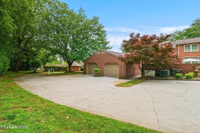 5039 Griffins Gate Ln, Knoxville, TN 37912 - view of front of house featuring central air condition unit, concrete driveway, an attached garage, and brick siding