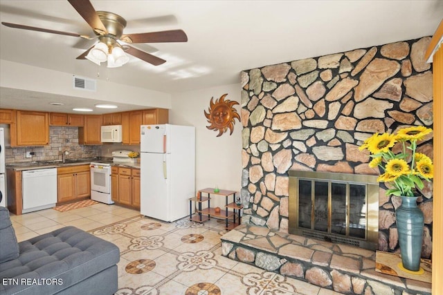 living area with light tile patterned floors, ceiling fan, and a fireplace