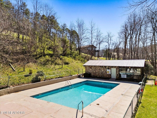 community pool featuring fence and a patio