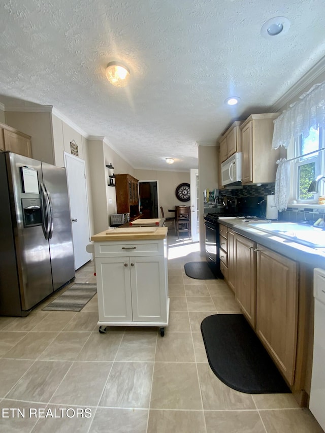 205 Browder Rd, Kingston, TN 37763 - kitchen with a textured ceiling, ornamental molding, white microwave, stainless steel fridge, and black range with gas stovetop