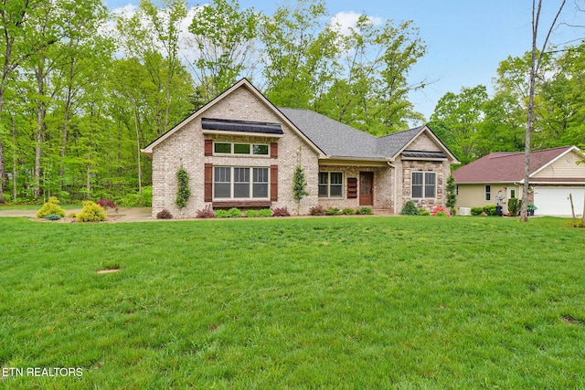 view of front of house featuring a front lawn, brick siding, and roof with shingles