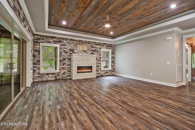 unfurnished living room featuring a raised ceiling, wooden ceiling, wood finished floors, a glass covered fireplace, and crown molding