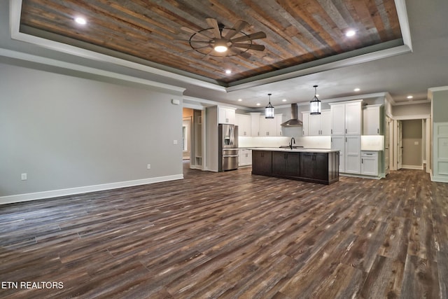 kitchen featuring a tray ceiling, stainless steel refrigerator with ice dispenser, wall chimney exhaust hood, a sink, and wood ceiling
