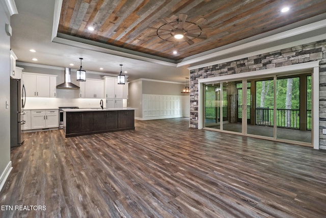 unfurnished living room with a raised ceiling, wood ceiling, dark wood-type flooring, a sink, and a ceiling fan
