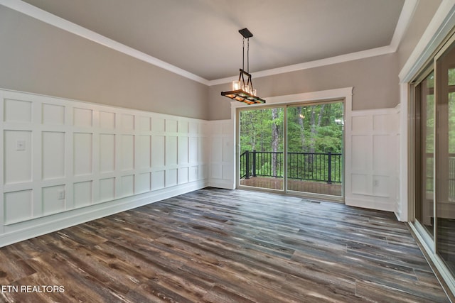 unfurnished dining area featuring a decorative wall, wainscoting, crown molding, and dark wood-style flooring