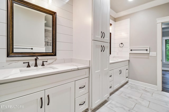 full bath featuring vanity, marble finish flooring, and baseboards