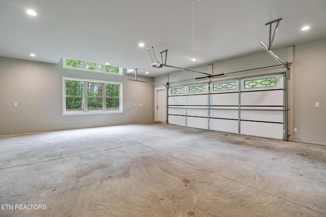garage with a garage door opener and recessed lighting