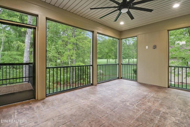 unfurnished sunroom with a ceiling fan and plenty of natural light