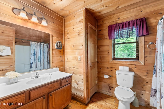 bathroom with wooden walls, toilet, wood-type flooring, vanity, and a shower with curtain