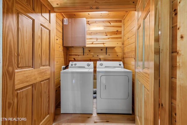 washroom with washer and clothes dryer, wooden walls, and wood ceiling