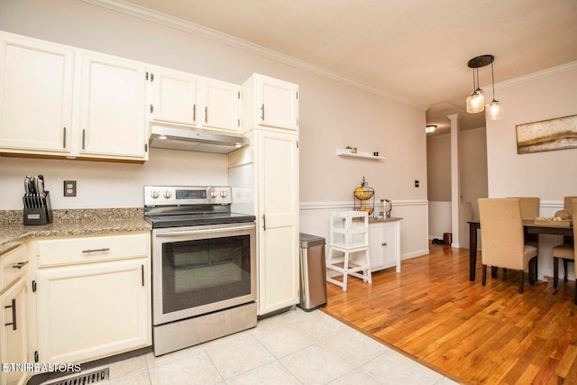 kitchen with electric range, under cabinet range hood, crown molding, light tile patterned floors, and ornate columns