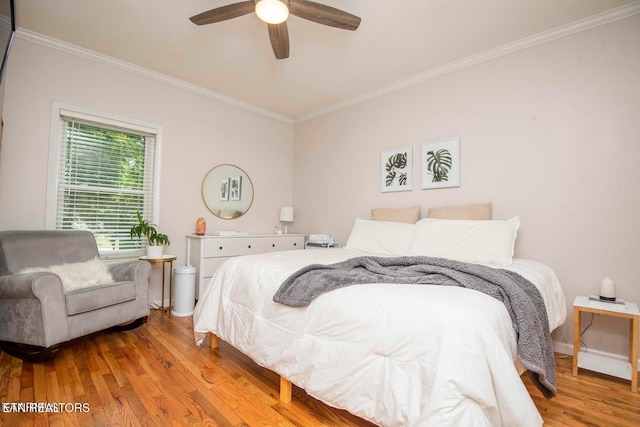 bedroom featuring crown molding, wood finished floors, and a ceiling fan