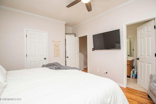 bedroom with crown molding, light wood-style floors, baseboards, ensuite bathroom, and a ceiling fan