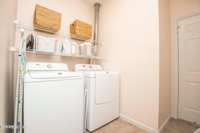 laundry area with separate washer and dryer and baseboards