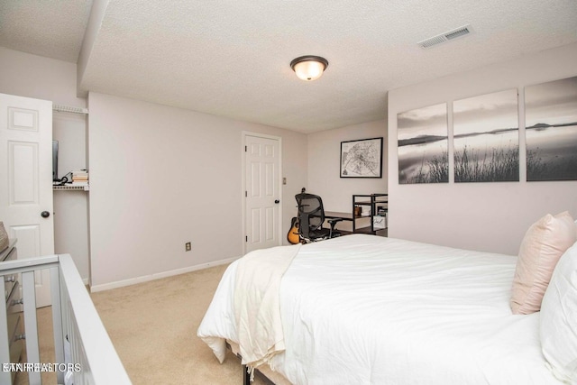 carpeted bedroom with a textured ceiling and baseboards