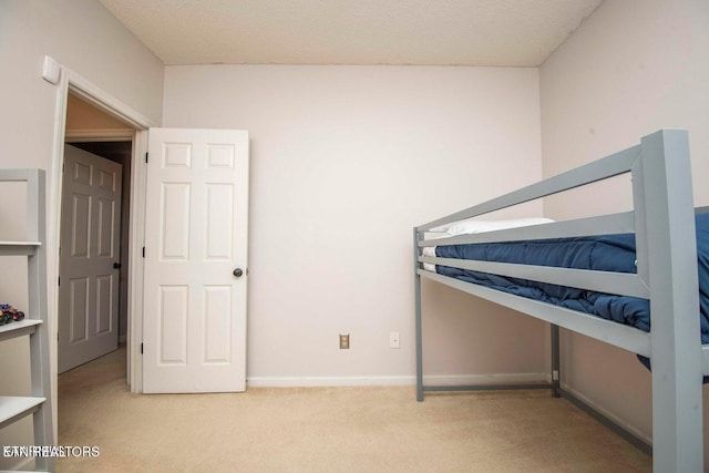 unfurnished bedroom featuring carpet, baseboards, and a textured ceiling