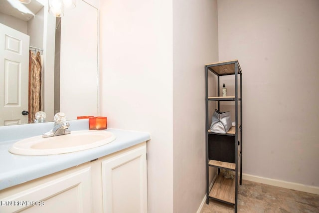 bathroom featuring vanity, baseboards, and stone finish floors