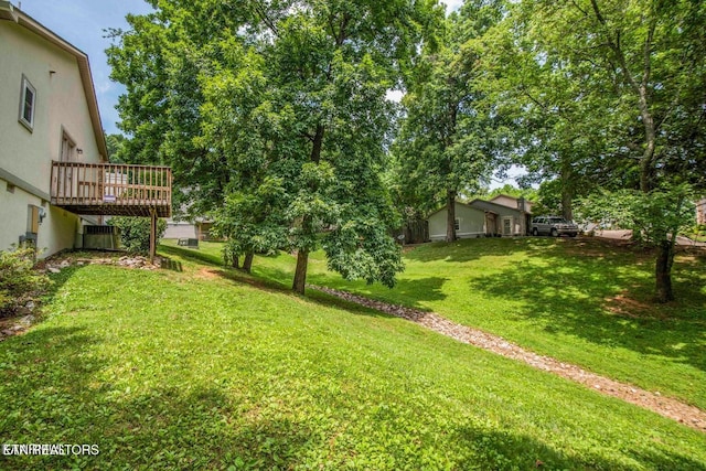 view of grassy yard with a wooden deck