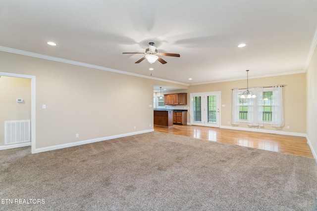 unfurnished living room featuring light colored carpet, ceiling fan, baseboards, recessed lighting, and crown molding