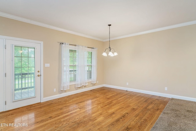 unfurnished dining area with ornamental molding, light wood-style flooring, plenty of natural light, a chandelier, and baseboards