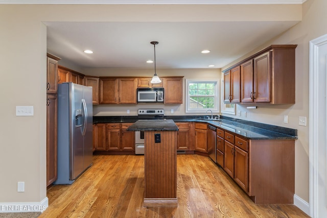 kitchen with appliances with stainless steel finishes, light wood-style flooring, a center island, a sink, and recessed lighting
