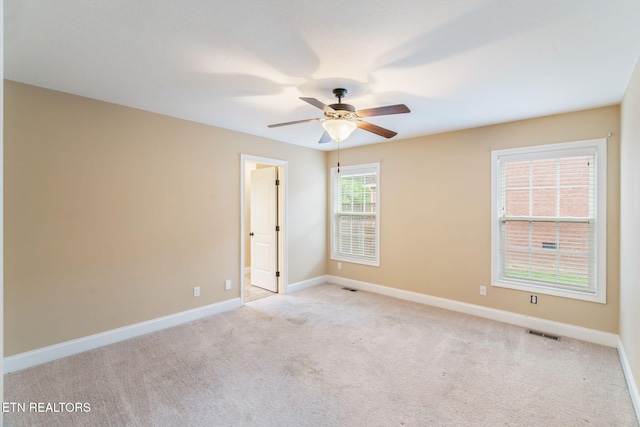 carpeted empty room with a ceiling fan and baseboards