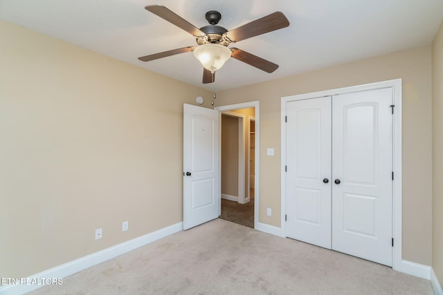 unfurnished bedroom featuring light carpet, a closet, and baseboards