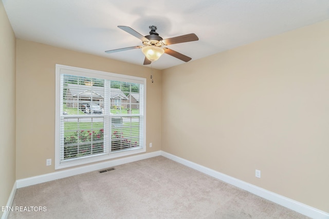 empty room featuring carpet flooring, baseboards, and ceiling fan