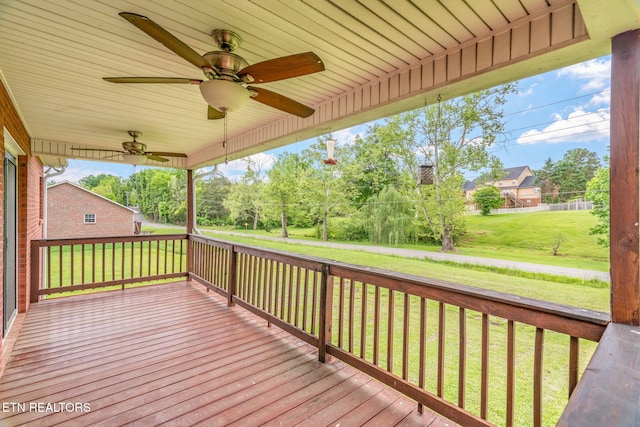 wooden deck featuring ceiling fan and a yard