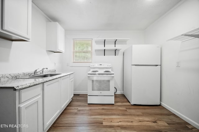 kitchen with white appliances, a sink, white cabinetry, wood finished floors, and light countertops