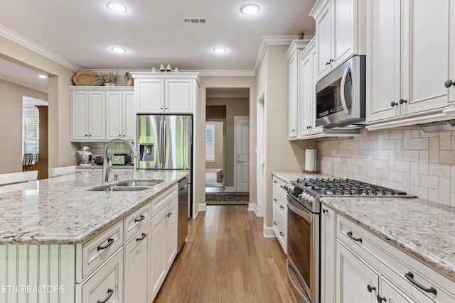 462 Chapel Grove Ln, Knoxville, TN 37934 - kitchen featuring appliances with stainless steel finishes, crown molding, tasteful backsplash, an island with sink, and white cabinets