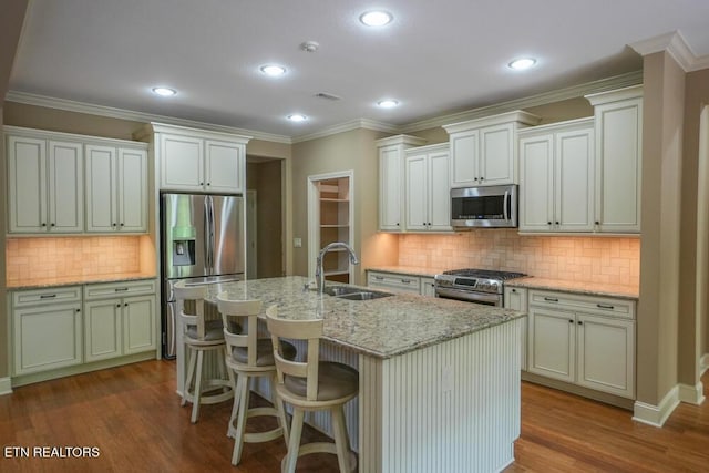 462 Chapel Grove Ln, Knoxville, TN 37934 - kitchen featuring appliances with stainless steel finishes, backsplash, wood finished floors, an island with sink, and light stone counters