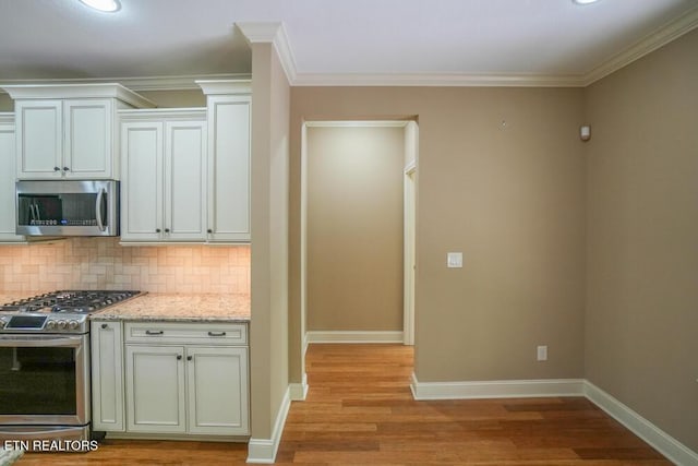 462 Chapel Grove Ln, Knoxville, TN 37934 - kitchen featuring stainless steel appliances, decorative backsplash, light wood-style floors, light stone counters, and crown molding