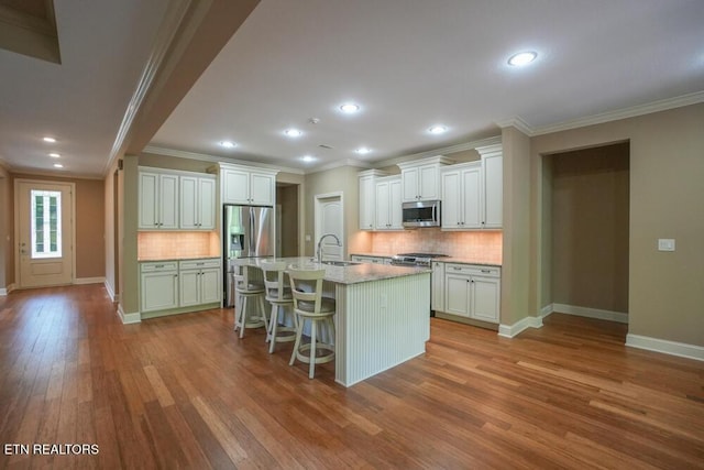 462 Chapel Grove Ln, Knoxville, TN 37934 - kitchen with stainless steel appliances, ornamental molding, wood finished floors, decorative backsplash, and a kitchen bar