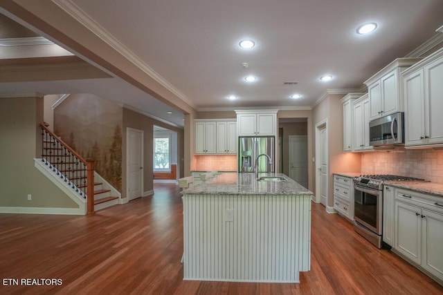 462 Chapel Grove Ln, Knoxville, TN 37934 - kitchen featuring appliances with stainless steel finishes, wood finished floors, decorative backsplash, light stone counters, and crown molding