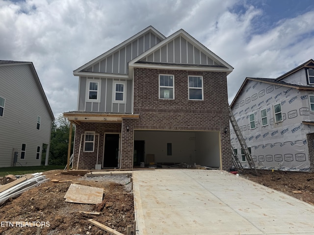view of front of house featuring board and batten siding, brick siding, driveway, and an attached garage