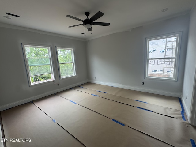 unfurnished room featuring baseboards, a ceiling fan, and crown molding