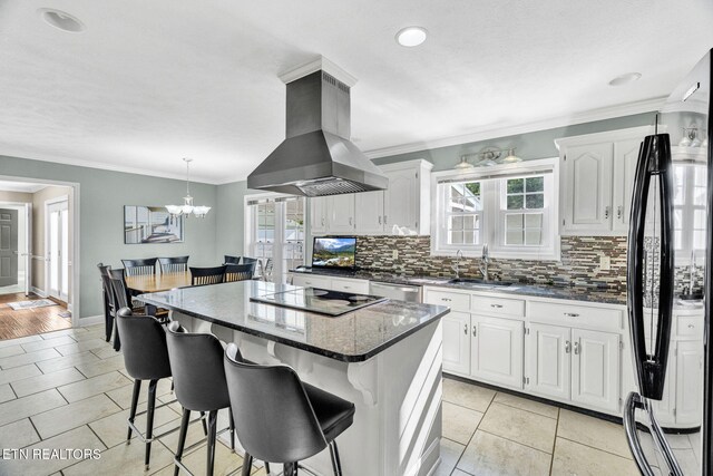 1182 Murrell Rd, Morristown, TN 37814 - kitchen featuring black appliances, island exhaust hood, a sink, backsplash, and a kitchen island