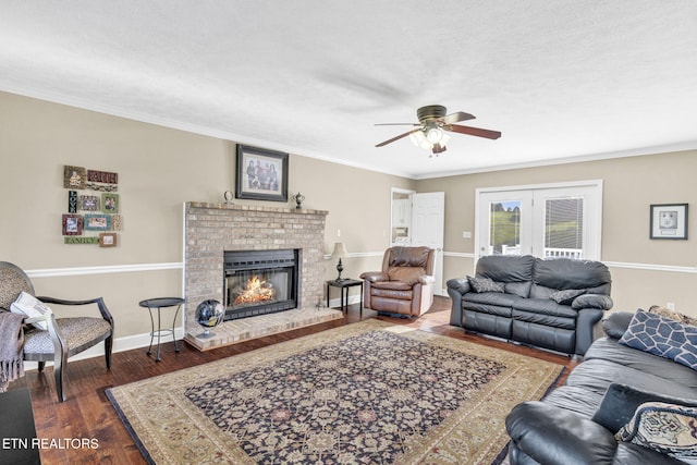 1182 Murrell Rd, Morristown, TN 37814 - living room featuring wood finished floors, a ceiling fan, a brick fireplace, crown molding, and baseboards