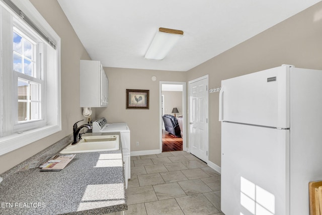 1182 Murrell Rd, Morristown, TN 37814 - washroom featuring cabinet space, baseboards, washer and dryer, and light tile patterned floors