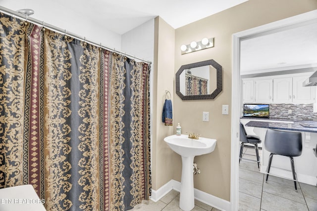 1182 Murrell Rd, Morristown, TN 37814 - bathroom with tile patterned floors, decorative backsplash, curtained shower, baseboards, and a sink