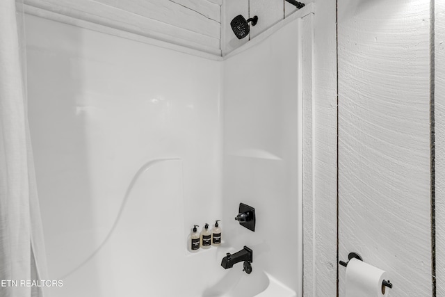 bathroom view of washtub / shower combination