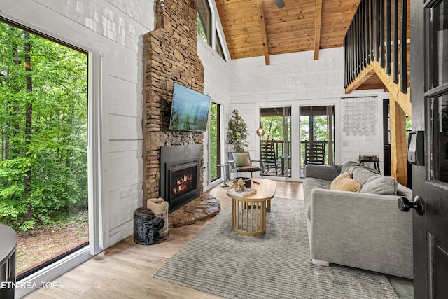 living room with wood finished floors, wood ceiling, beamed ceiling, a fireplace, and high vaulted ceiling