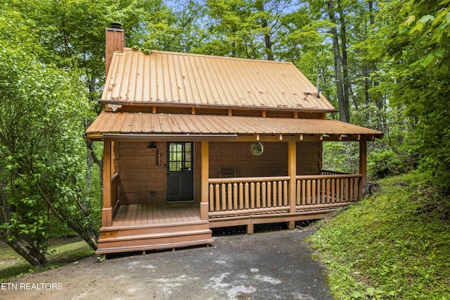 chalet / cabin with a chimney and metal roof