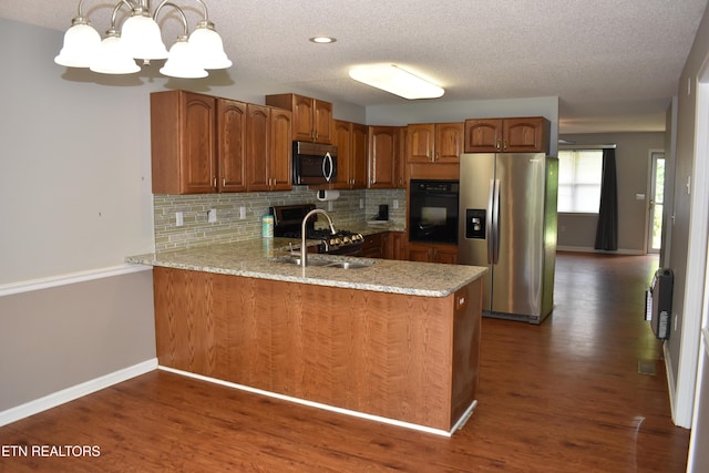 33 Wood Ln, Sparta, TN 38583 - kitchen featuring appliances with stainless steel finishes, a sink, brown cabinetry, decorative backsplash, and a peninsula